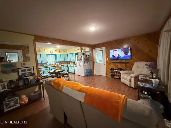 a living room with furniture a flat screen tv and a floor to ceiling window