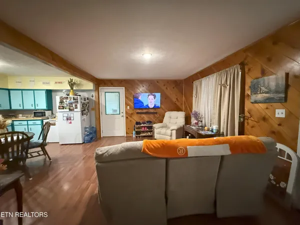 a living room with furniture a flat screen tv and a large window