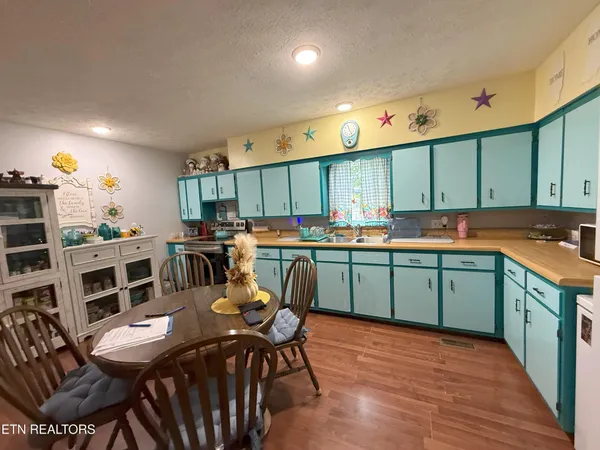 a kitchen with stainless steel appliances a table chairs and a refrigerator