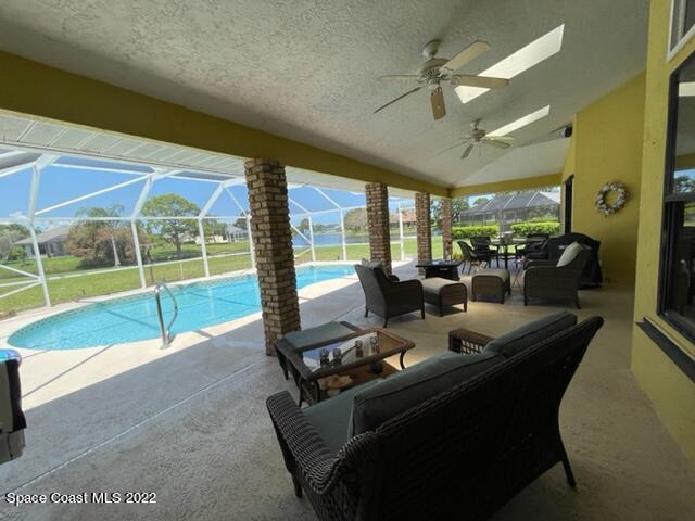 866 Spanish Wells Drive Melbourne, FL 32940 - Photo 3 of 18 a living room with patio furniture and a floor to ceiling window
