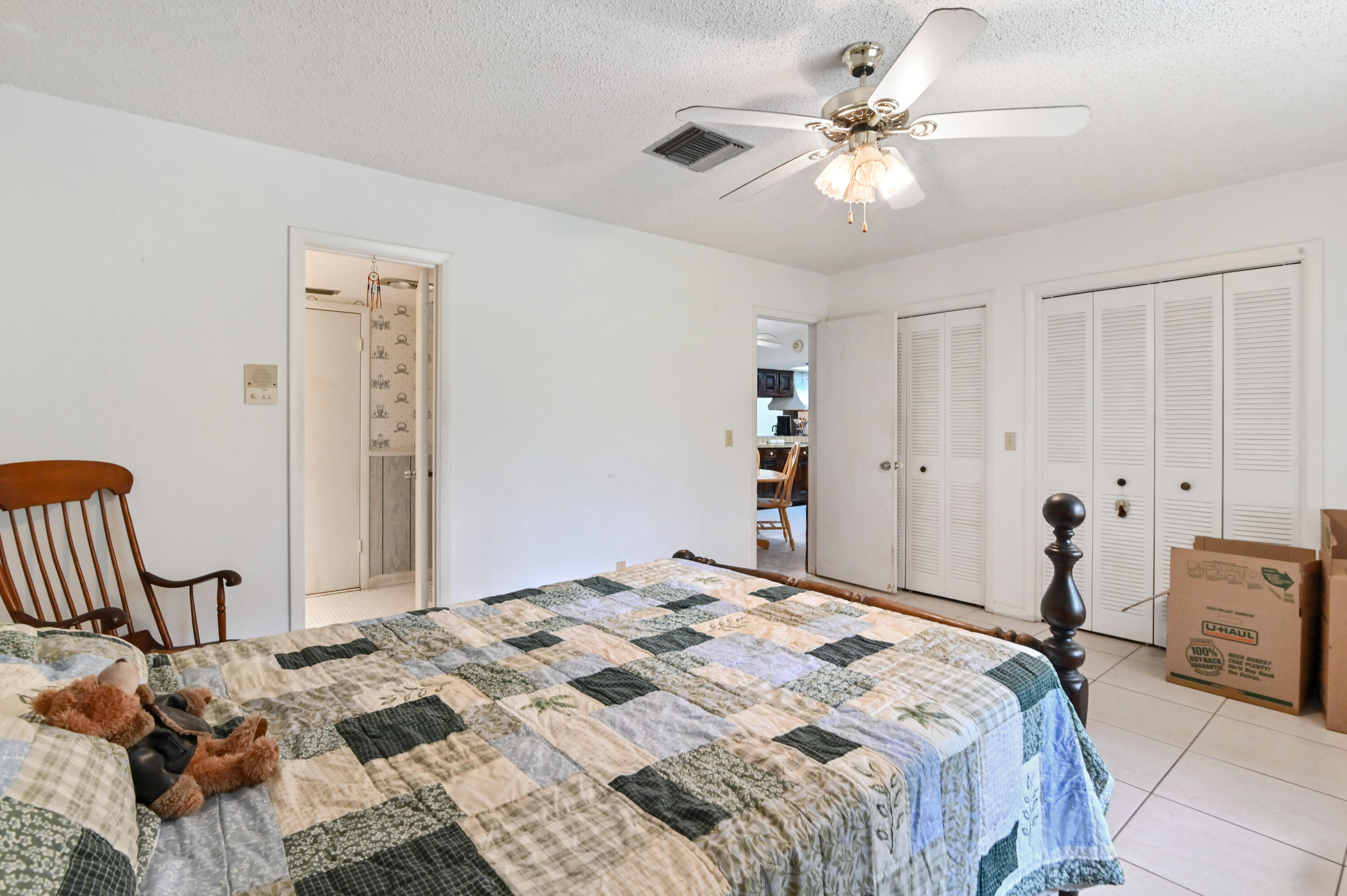 3208 A Road Loxahatchee Groves, FL 33470 - Photo 28 of 51 a bedroom with a bed and a chandelier