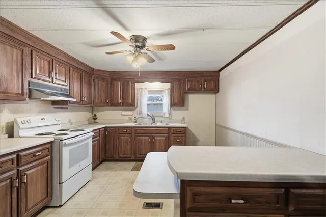 a kitchen with stainless steel appliances granite countertop a stove sink refrigerator and cabinets
