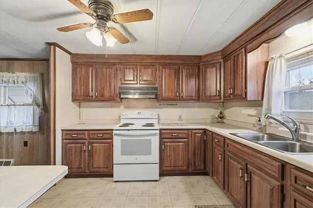 a kitchen with stainless steel appliances granite countertop a sink a stove cabinets and a refrigerator