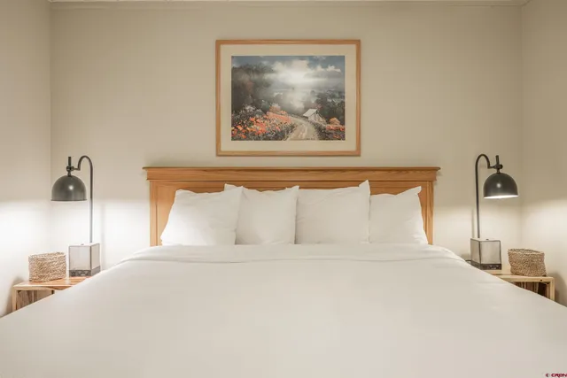 a bedroom with a bed and a painting on the wall