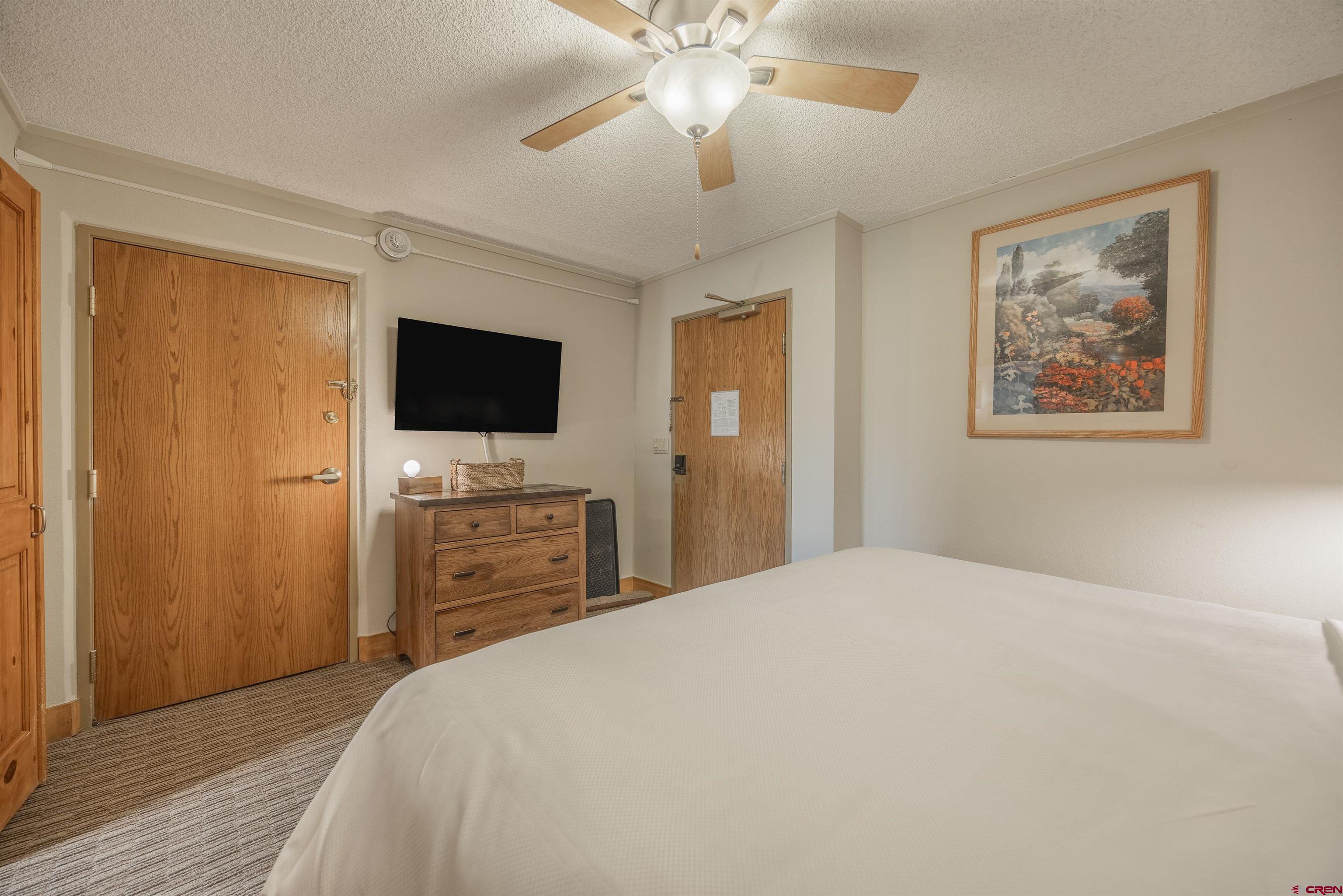 6 Emmons Road, Unit 553 Crested Butte, CO 81225 - Photo 3 of 27 a bedroom with a bed and a flat screen tv