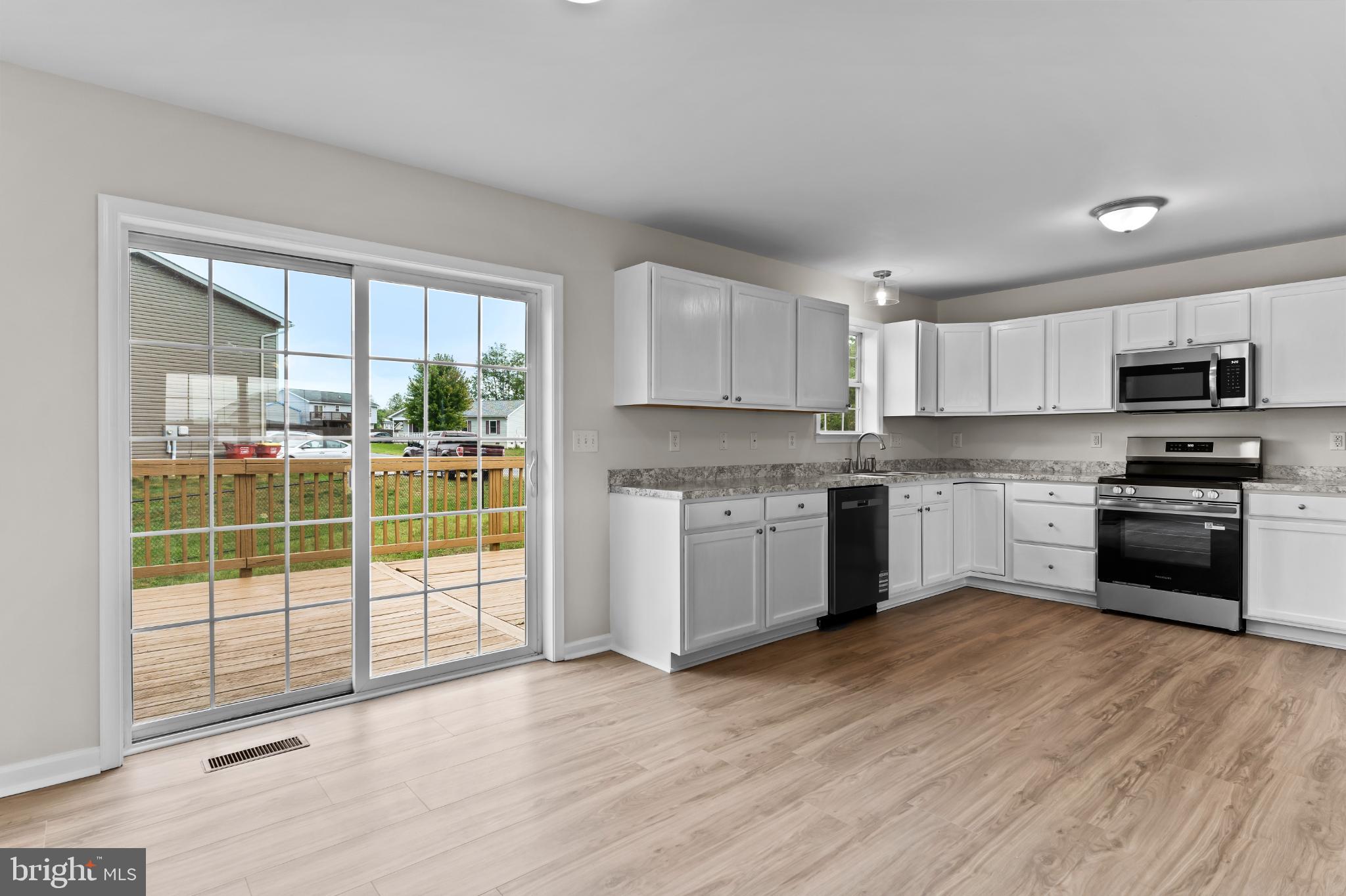 99 Middle Spring Road Shippensburg, PA 17257 - Photo 8 of 27 a kitchen with granite countertop a stove a sink and a microwave