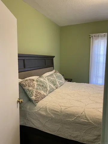 a bed sitting in a bedroom next to a wooden cabinet