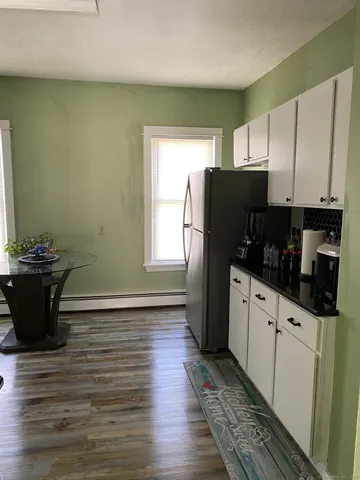 a kitchen with granite countertop a refrigerator and a stove top oven