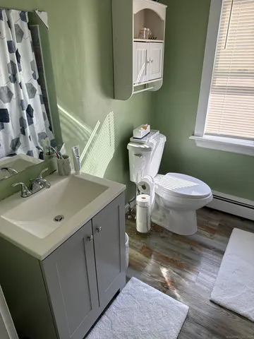 a bathroom with a toilet sink and mirror