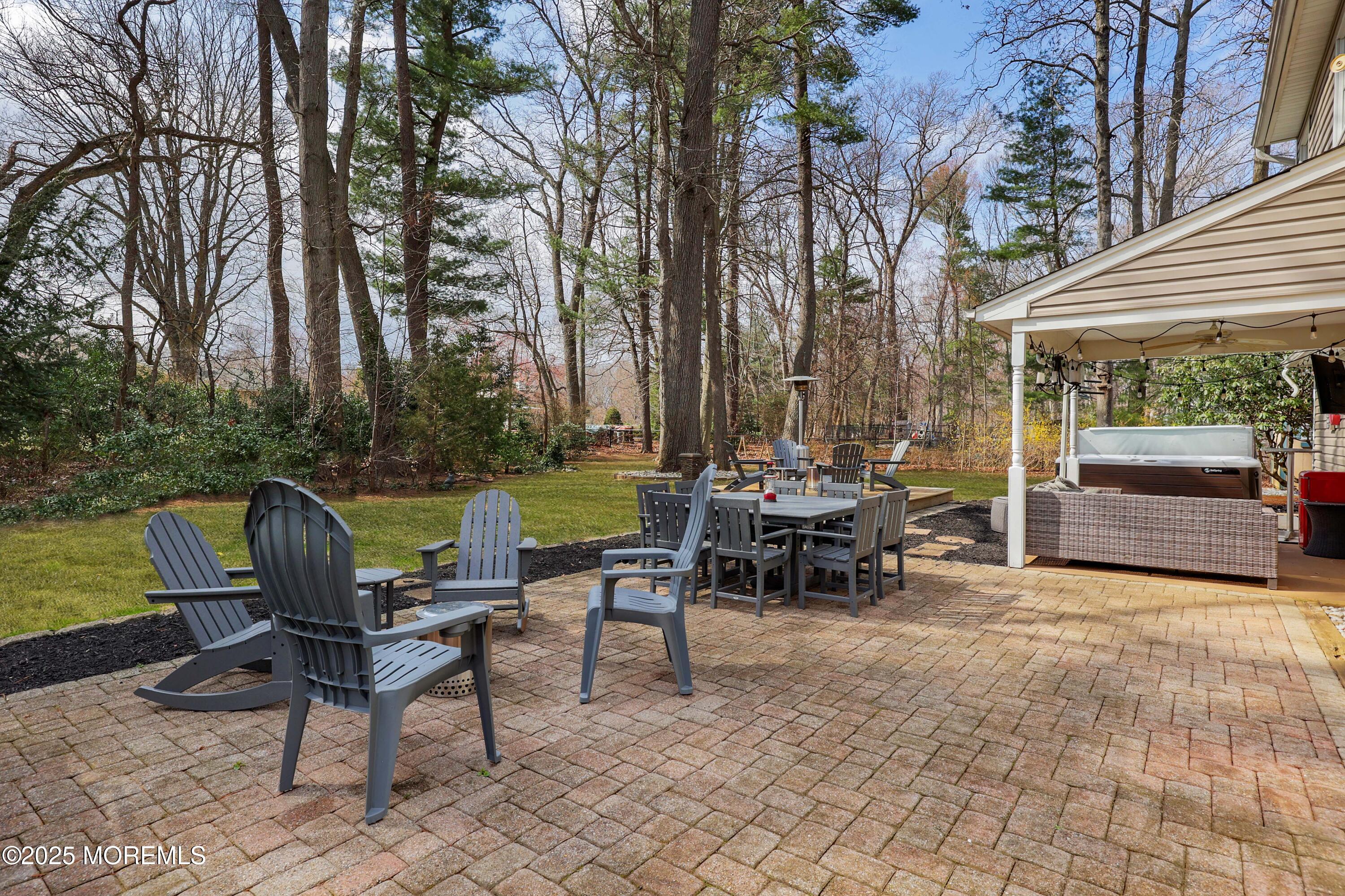125 Jumping Brook Road Lincroft, NJ 07738 - Photo 14 of 47 a view of a chairs and tables in the back yard of the house