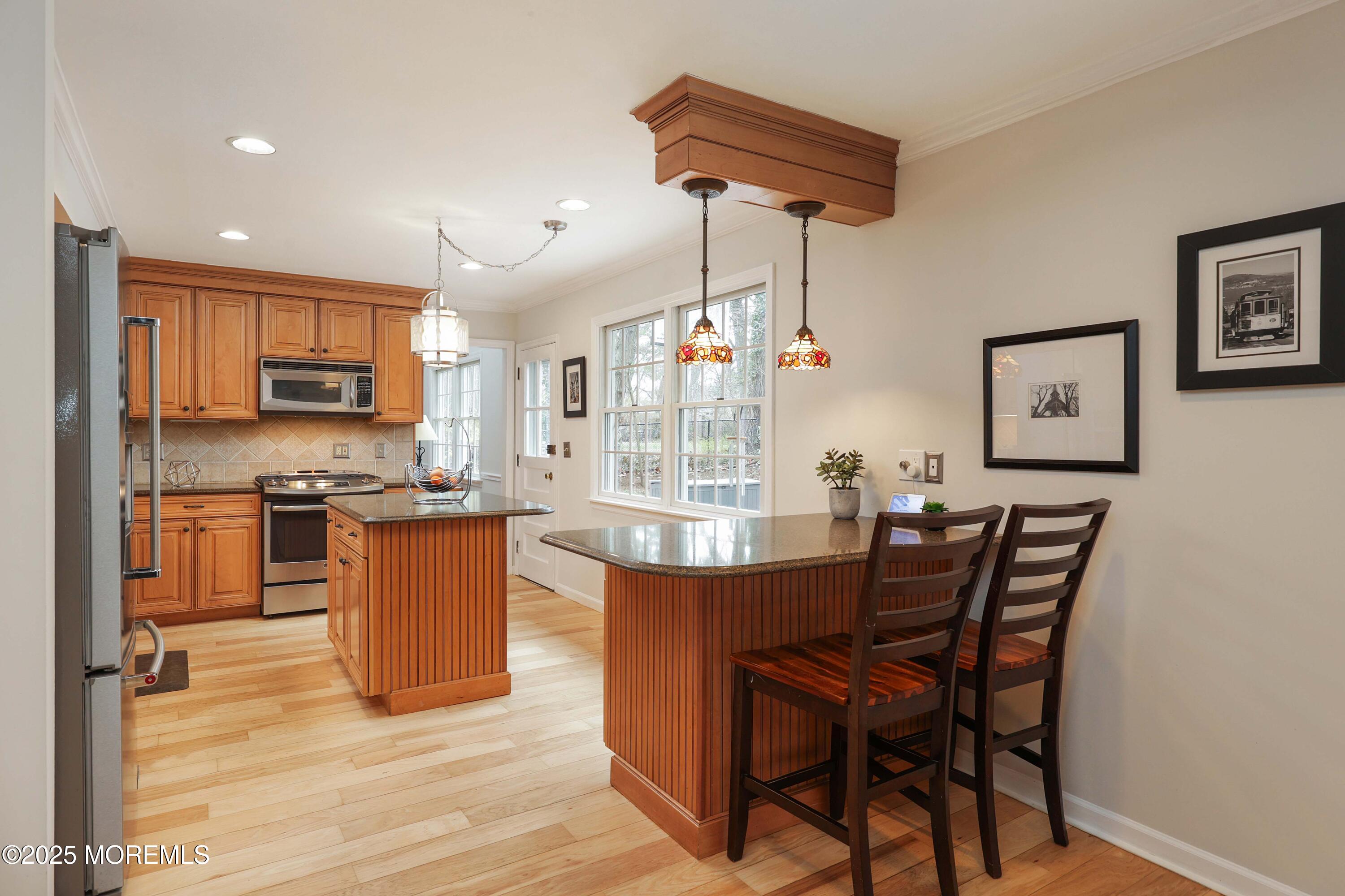 125 Jumping Brook Road Lincroft, NJ 07738 - Photo 28 of 47 a dining room with granite countertop wooden floor a refrigerator a sink a dining table and chairs