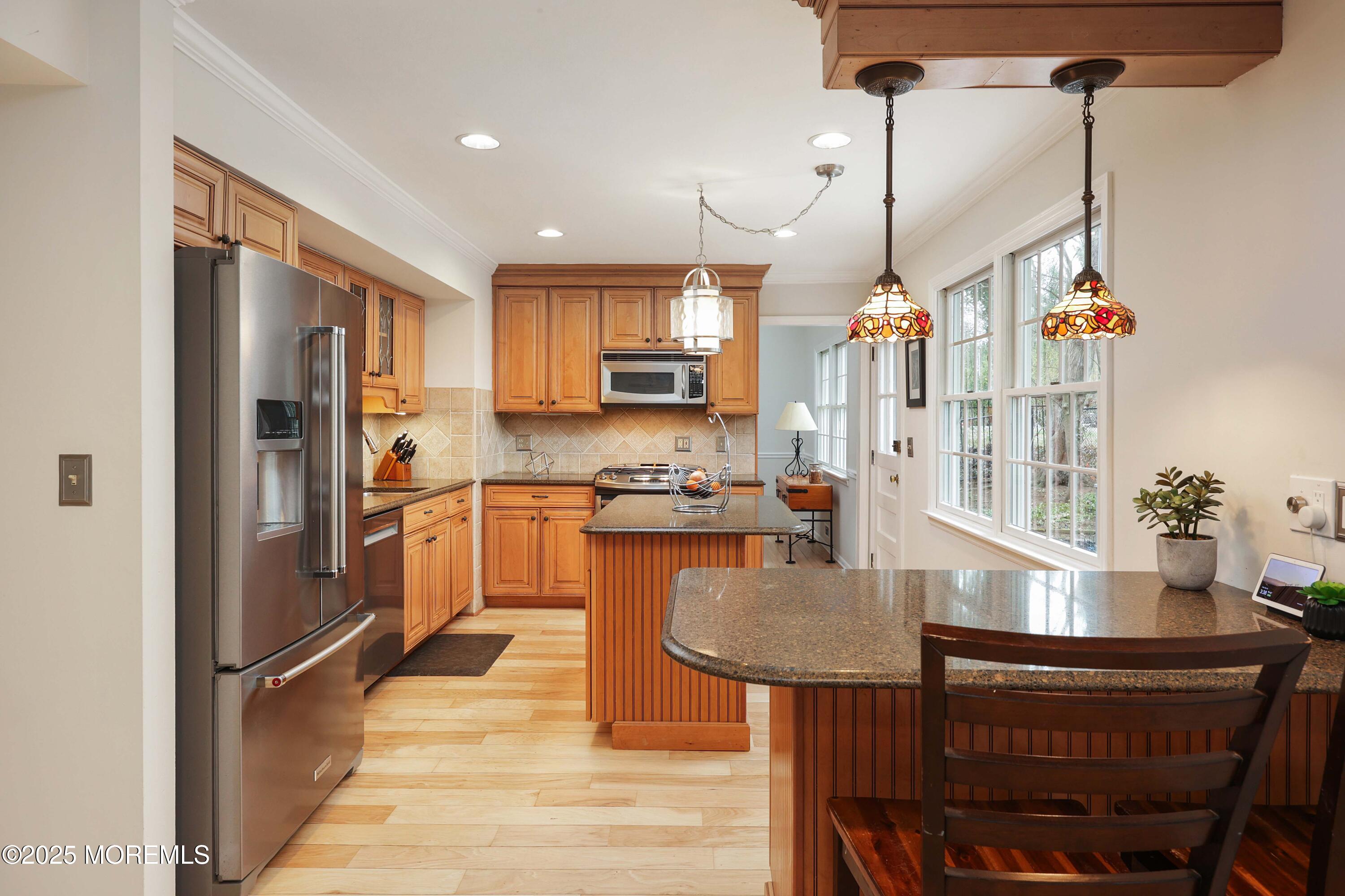 125 Jumping Brook Road Lincroft, NJ 07738 - Photo 29 of 47 a kitchen with granite countertop a refrigerator a stove a sink a dining table and chairs with wooden floor