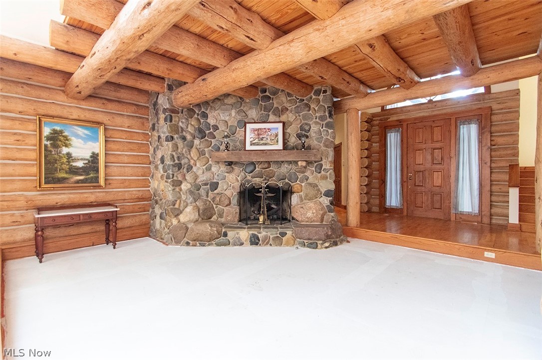 1871 Mattingly Road Hinckley, OH 44233 - Photo 4 of 50 Unfurnished living room featuring log walls, a fireplace, and wood ceiling