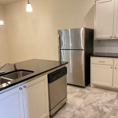 a kitchen with a refrigerator and a sink