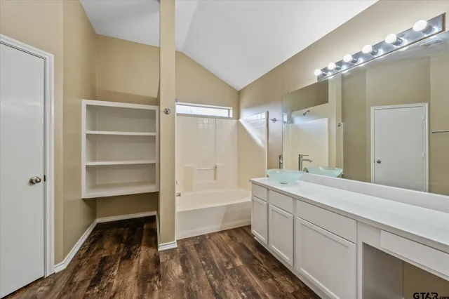 a bathroom with a tub sink and mirror