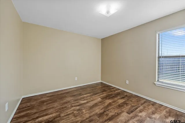 a view of a room with wooden floor and a window