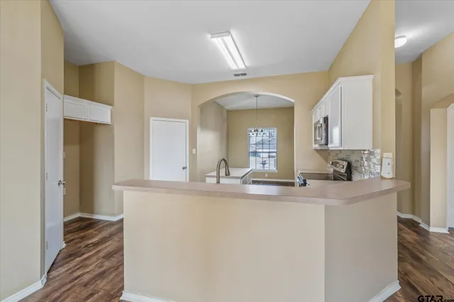 a kitchen with kitchen island a sink and a refrigerator