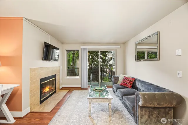a living room with furniture a flat screen tv and a fireplace