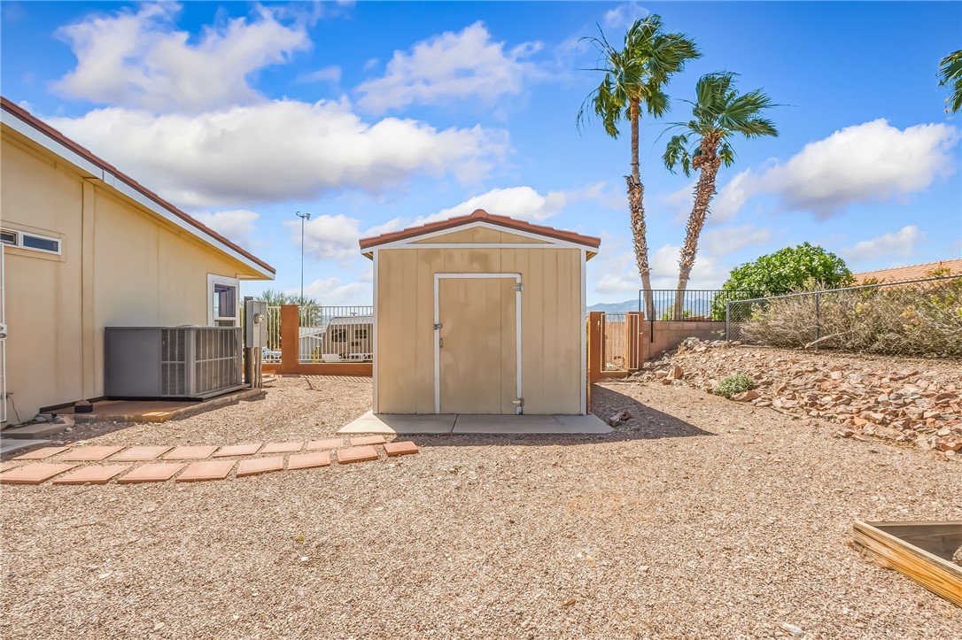 2525 South Ridge Avenue Bullhead City, AZ 86429 - Photo 10 of 76 Detached storage shed featuring a tiled roof and concrete pad, surrounded by gravel landscaping