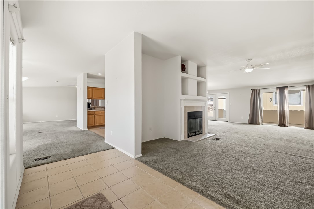2525 South Ridge Avenue Bullhead City, AZ 86429 - Photo 15 of 76 Carpeted living area featuring a built-in fireplace with mantel, recessed shelving, and a ceiling fan