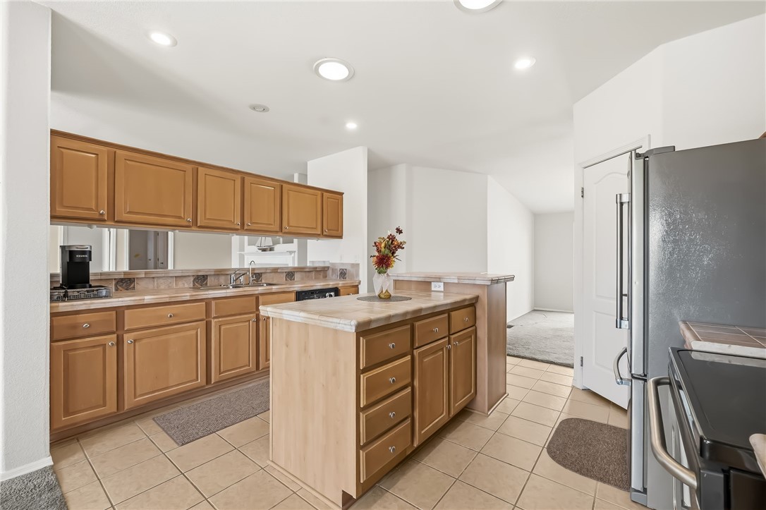 2525 South Ridge Avenue Bullhead City, AZ 86429 - Photo 22 of 76 Kitchen featuring a central island, recessed lighting, tile flooring, wood cabinetry, and stainless steel appliances