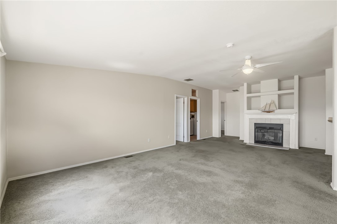 2525 South Ridge Avenue Bullhead City, AZ 86429 - Photo 32 of 76 Spacious living area featuring a built-in fireplace with mantel, integrated shelving, and carpet flooring