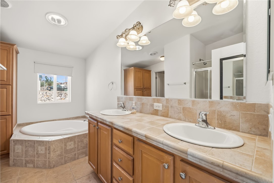2525 South Ridge Avenue Bullhead City, AZ 86429 - Photo 42 of 76 Dual vanity with warm wood-finish cabinetry, tile countertop, and integrated sinks