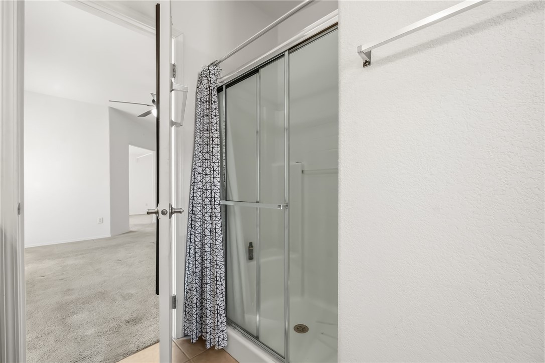 2525 South Ridge Avenue Bullhead City, AZ 86429 - Photo 44 of 76 Shower enclosure with sliding glass doors and a white base, complemented by light-colored wall textures and a chrome towel bar