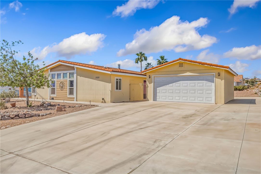 2525 South Ridge Avenue Bullhead City, AZ 86429 - Photo 4 of 76 Expansive concrete driveway servicing a single-story residence and a detached two-car garage