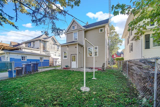 a view of a house with a yard and a large tree