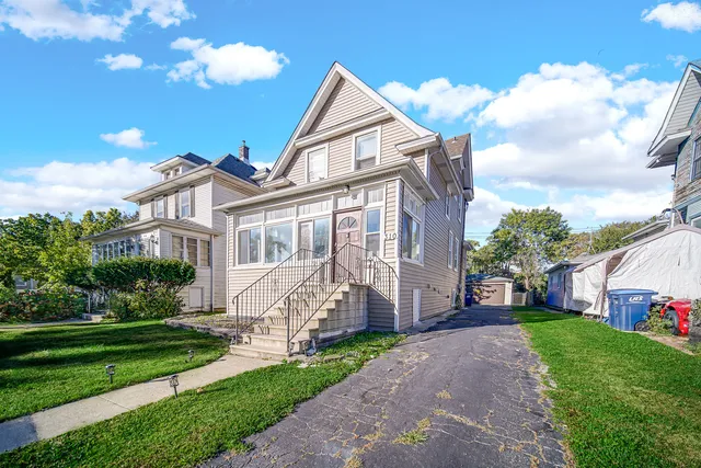a front view of a house with a garden and plants