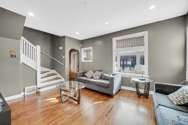 a living room with furniture and a wooden floor