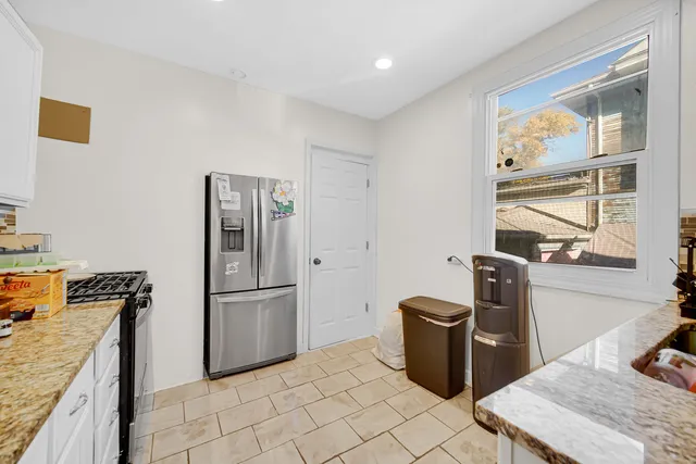 a kitchen with stainless steel appliances granite countertop a refrigerator a stove and a sink