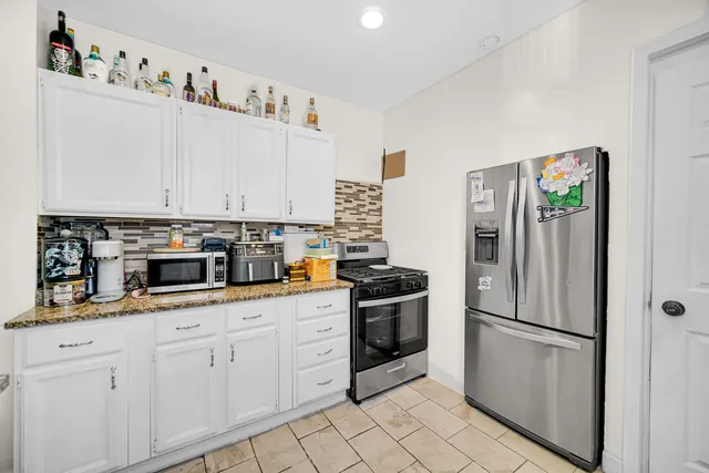 a kitchen with stainless steel appliances granite countertop a refrigerator sink and stove