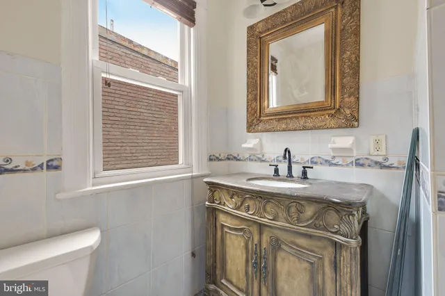 a bathroom with a granite countertop sink toilet and mirror