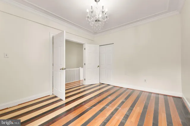 a view of a room with wooden floor and a ceiling fan