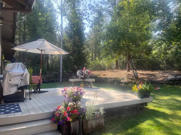 a view of a table and chairs in backyard of the house