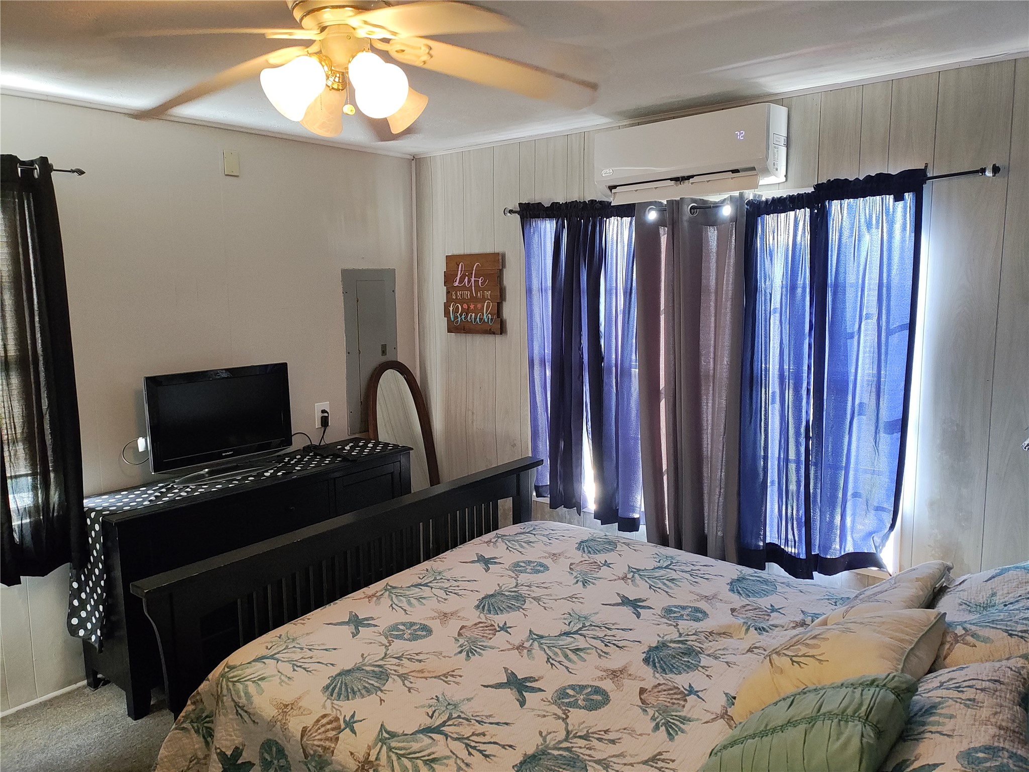 415 Seashell Drive Surfside Beach, TX 77541 - Photo 8 of 10 Bedroom featuring ceiling fan, a wall unit AC, carpet floors, and electric panel