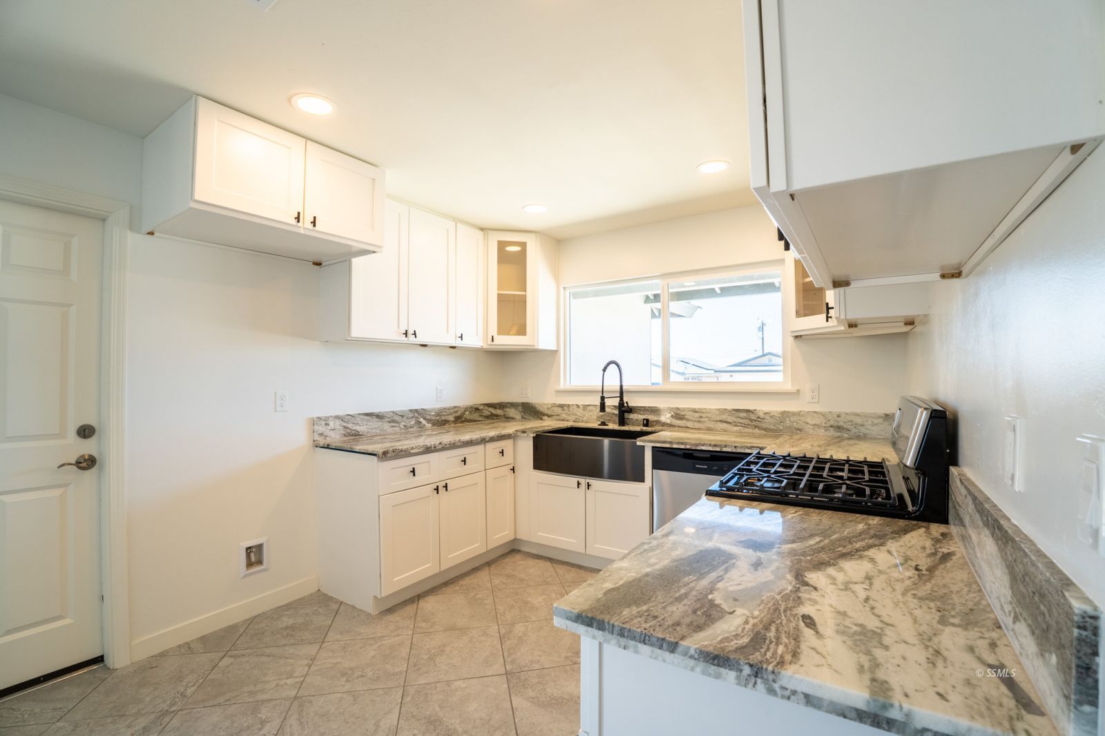 1529 Mayo Street Ridgecrest, CA 93555 - Photo 10 of 22 a kitchen with granite countertop a stove a sink and a refrigerator