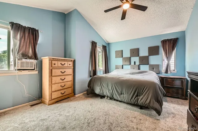 a spacious bedroom with a bed and a chandelier