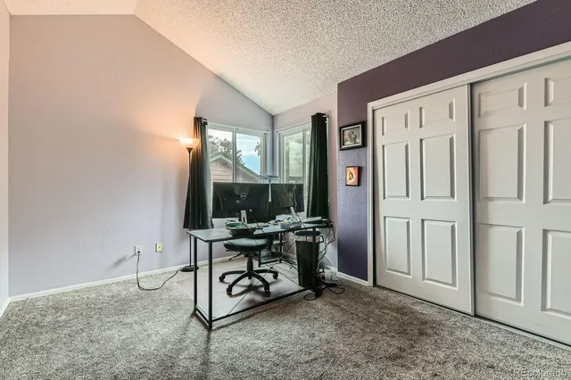a view of a workspace with furniture and a window