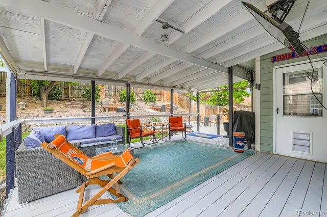 an outdoor sitting area with couch and wooden floor