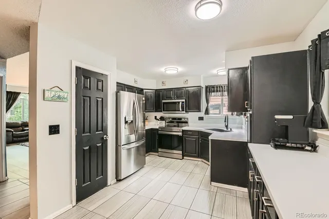 a kitchen with stainless steel appliances kitchen island granite countertop a refrigerator and a stove top oven