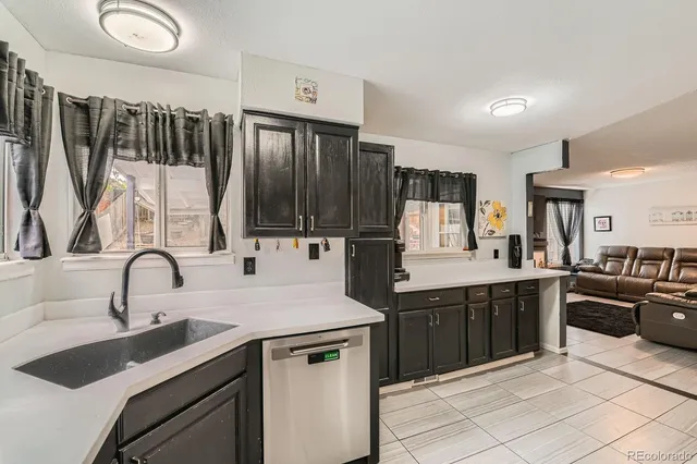 a kitchen with granite countertop a sink stainless steel appliances and cabinets