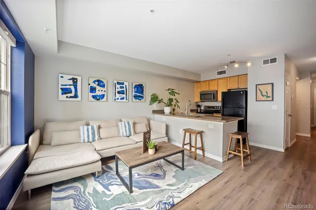 a living room with furniture and a dining table with kitchen view