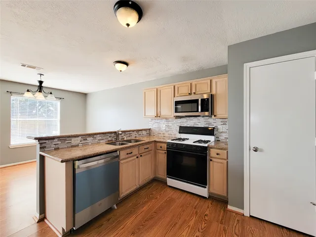 a kitchen with stainless steel appliances granite countertop a stove and a microwave