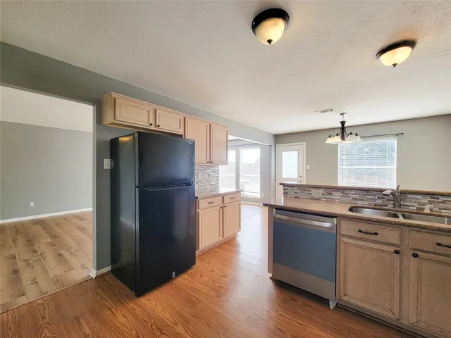 a kitchen with stainless steel appliances granite countertop a refrigerator a sink and a stove