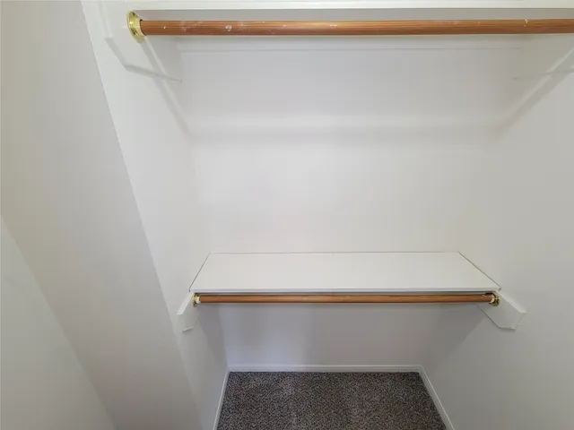 an empty room with windows and ceiling fan