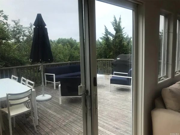 a balcony with wooden floor table and chairs