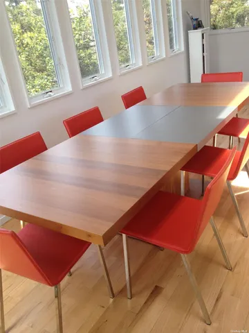a dining room with furniture a rug and a floor to ceiling window